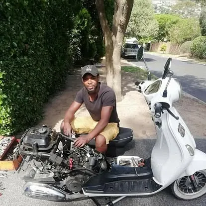 Erik working on a white scooter engine